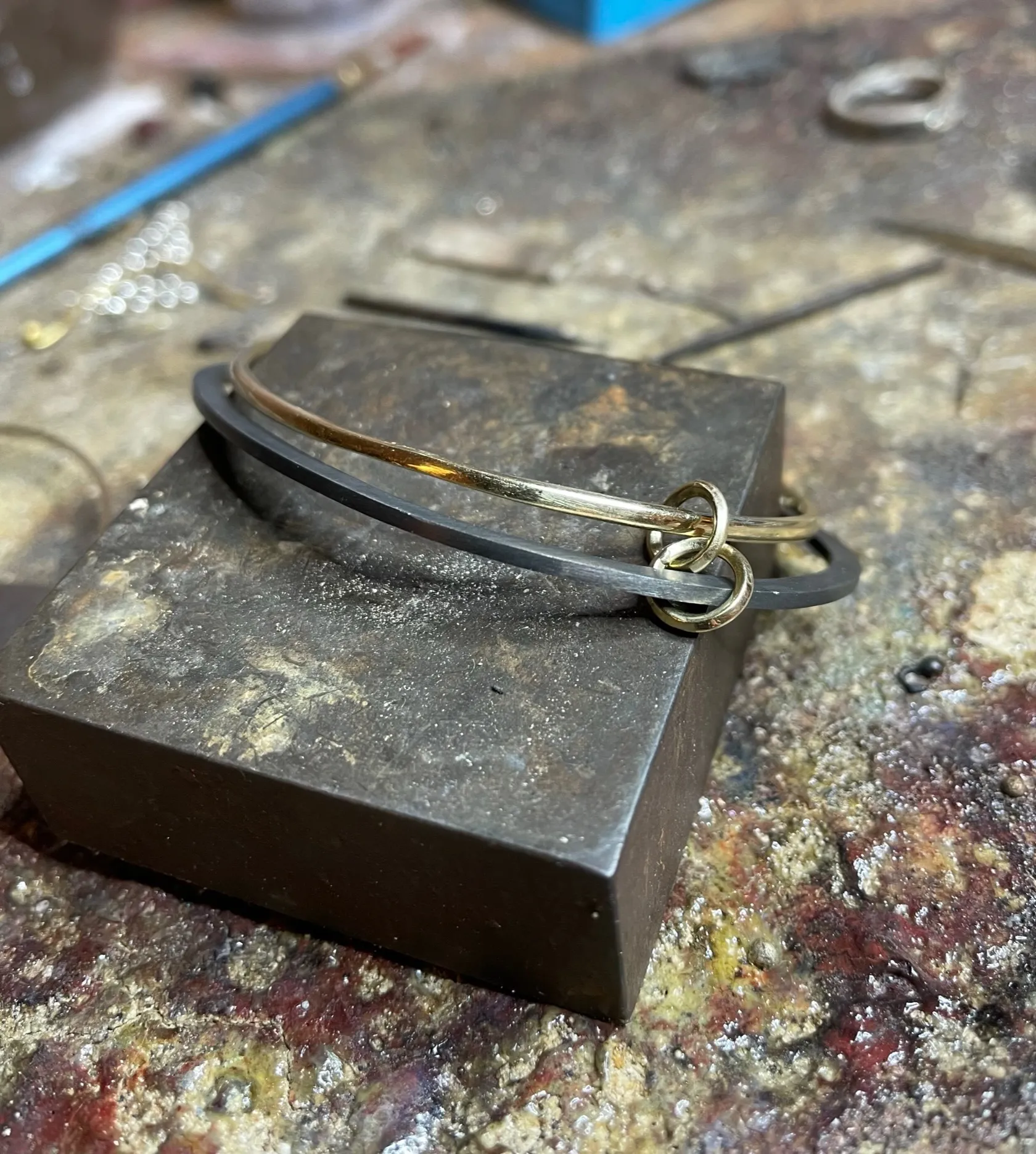 Slanke titanium bangle met gouden scharniersluiting