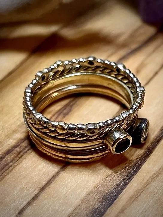 Stapel gouden ringen met verschillende bewerkingen en onyx