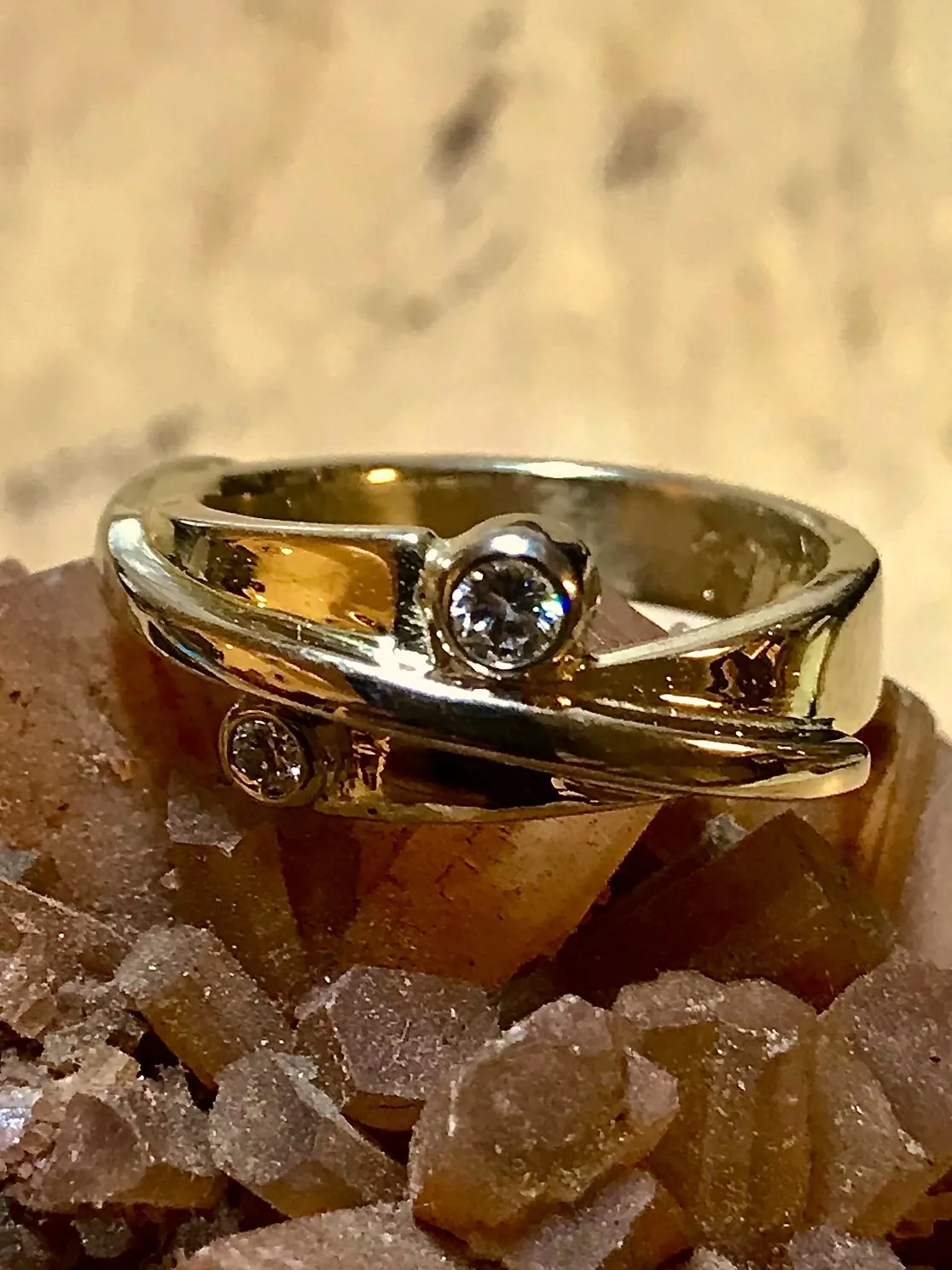 Brede gouden ring met centrale diamant en kleinere steen