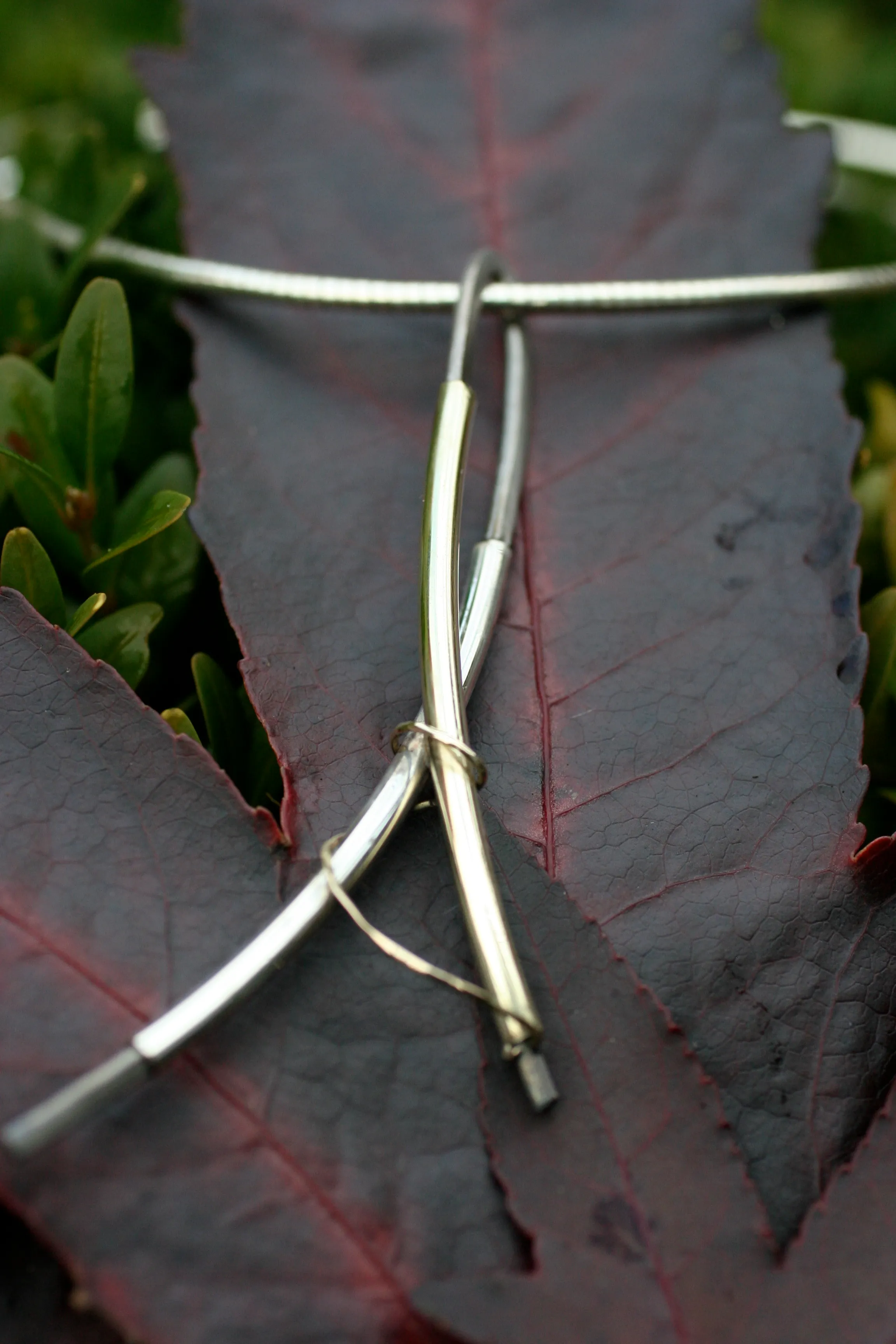 Hanger met gekruiste gouden staafjes aan zilveren omega collier