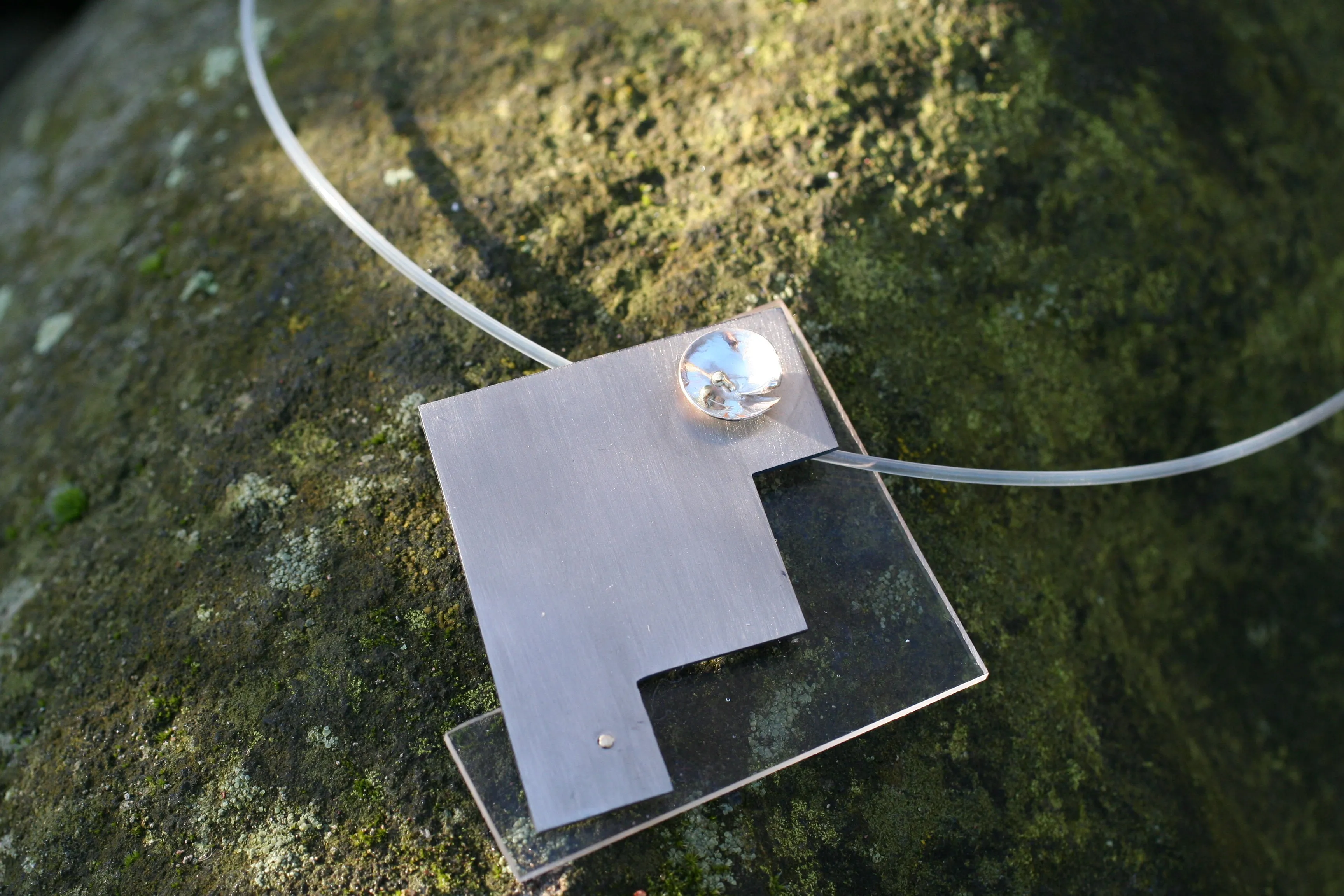 Geometrische hanger in titanium en plexiglas met zilveren schotel